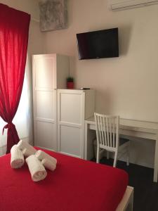 罗马德古斯蒂伯斯酒店的一间卧室配有一张红色的床、一张桌子和红色窗帘