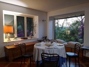 马戈马达斯La Tinaia Country House的一间带桌椅和窗户的用餐室