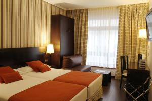 毕尔巴鄂康德杜克毕尔巴鄂酒店的配有一张床和一把椅子的酒店客房