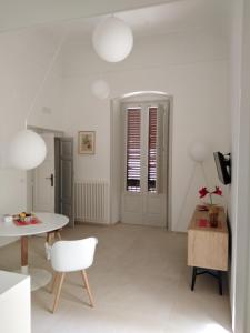 鲁蒂利亚诺Palazzo Iato的白色的客厅配有桌子和椅子