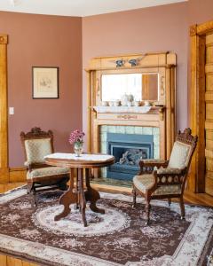 BarreReynolds House Inn的客厅配有桌椅和壁炉