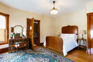 BarreReynolds House Inn的一间卧室配有一张床、一张桌子和一面镜子