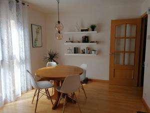 博尔塔纳Apartamento Serreria de Boltaña的一间带木桌和白色椅子的用餐室