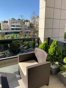 拉马拉Ramallah Modern Apartment的阳台配有藤椅和一些植物