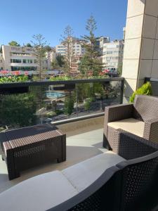 拉马拉Ramallah Modern Apartment的阳台的天井配有2把椅子和1张桌子