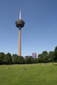 科隆Weltempfänger Backpacker Hostel的公园里一座塔楼,人们躺在草地上