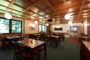 哈拉霍夫Pension Venus的餐厅设有木制天花板和桌椅