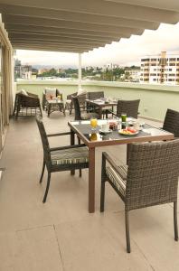 圣萨尔瓦多Suites las Palmas, Hotel & Apartments.的阳台上的桌椅,上面有饭