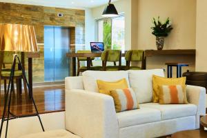 圣萨尔瓦多Suites las Palmas, Hotel & Apartments.的客厅配有白色的沙发和桌子