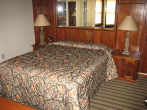 斯廷博特斯普林斯Sunburst Condominiums, a VRI resort的一间卧室配有一张床、两盏灯和一面镜子