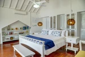 巴尔阿瓜阿苏尔海滩度假村的白色卧室配有床和吊扇