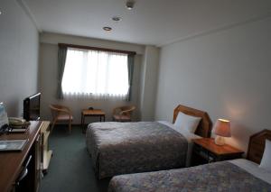 东村山市森特皮亚酒店的酒店客房设有两张床和电视。