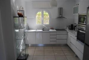 德尼亚Villa Bozena的白色的厨房设有水槽和窗户