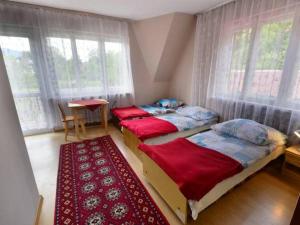 扎沃亚Trybałowa Ostoja的一间卧室设有两张床、一张桌子和窗户。