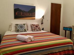里约热内卢Studio2 Rio Beira Mar的一间卧室配有一张带彩色毯子和枕头的床。