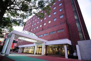 仓吉市Kurayoshi City Hotel的前面有走道的大型红砖建筑