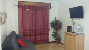 里斯本Studio Telheiras的带沙发和红色窗帘的客厅