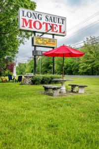 Long Sault常索尔特汽车旅馆的汽车旅馆旁带红伞的野餐桌