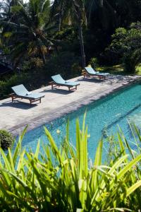 特贾库拉Gaia-Oasis Mountain Abasan的游泳池旁的三把躺椅