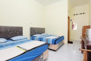 日惹Hotel Wijaya 2 Kaliurang的一间房间,有三张床