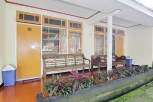 日惹Hotel Wijaya 2 Kaliurang的前面有长椅和植物的建筑