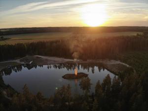 珀尔瓦Metsjärve apartments的日落时分湖中的一个岛屿
