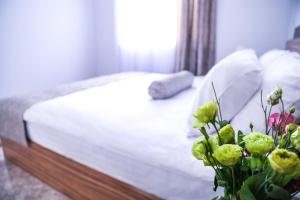 塞凡Garden Inn Resort Sevan的一间卧室配有床和花瓶