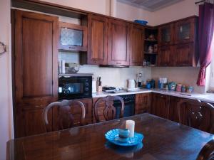 KhlóïStone house的厨房配有木制橱柜和桌椅