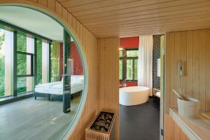 苏黎世Sorell Hotel Rigiblick - Studios & Spa Suites的一间带镜子和浴缸的浴室以及一间卧室