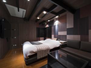 东京Hotel Crest Kinshicho (Adult Only)的一间卧室配有一张床和一张沙发