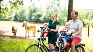 CromvoirtTopParken – Résidence de Leuvert的坐在自行车上,背靠马的家庭