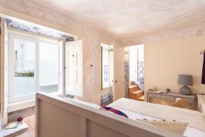 里斯本Archi-Pelago Alfama Design Suites Guesthouse的一间卧室设有一张床和一个窗口