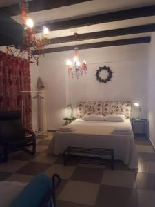 阿莫利亚尼岛多米尼奇旅馆的卧室配有白色的床和吊灯。