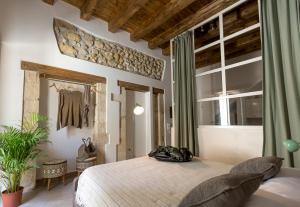 锡拉库扎Ortigia Boutique Palace的一间卧室配有一张大床和镜子