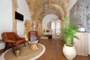 锡拉库扎Ortigia Boutique Palace的一间带椅子和植物的客厅