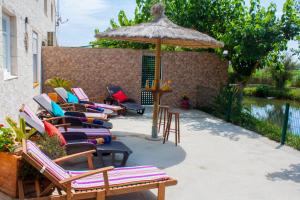 代尔特布雷Paradise Ebro 2的庭院里摆放着一组椅子和一把遮阳伞