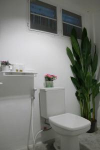 班怀扬班娜塔拉维安度假村的白色的浴室设有卫生间和植物