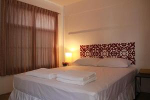 班怀扬班娜塔拉维安度假村的卧室配有白色床和毛巾