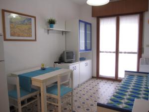 格拉多Appartamento Franco的小房间设有桌椅和电视