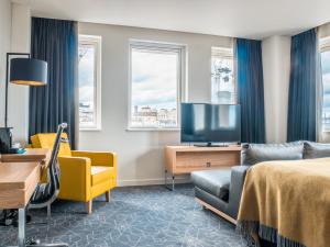 爱丁堡先瑞滑铁卢普雷斯酒店的酒店客房配有1张床、1台电视和1张沙发。