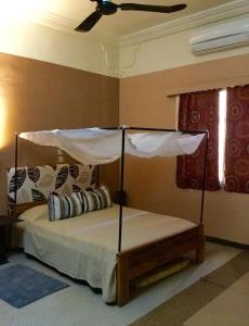 巴马科Auberge Djamilla的一间卧室配有一张带天蓬的床