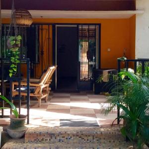 巴马科Auberge Djamilla的房屋的前门,房屋设有长凳和门廊
