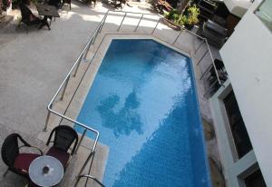 阿加迪尔新法拉酒店的蓝色游泳池的顶部景观,配有两把椅子
