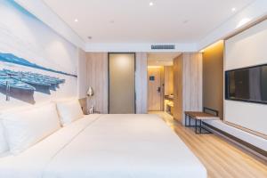 杭州杭州西湖文化广场亚朵酒店的一间卧室配有一张大床和一台平面电视