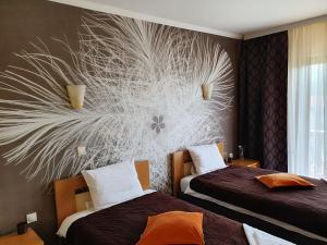弗拉迪钦汉Kompleks Fontana的酒店客房设有两张床,墙上挂有壁画