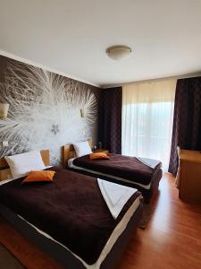 弗拉迪钦汉Kompleks Fontana的两张位于酒店客房的床,墙上挂着壁画