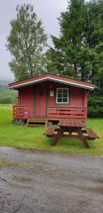 IsfjordenRomsdalseggen Camping的一间红色小屋,前面设有野餐桌
