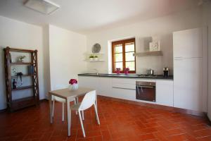 波贾尔多Villa Topazio的厨房配有白色橱柜和桌椅