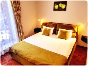 维尔纽斯Vivulskis Apart-Hotel的一间卧室配有带白色床单和黄色枕头的床。
