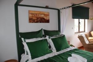 维拉·雷阿尔A Casa da Sofia的一间卧室配有带绿色和白色枕头的床